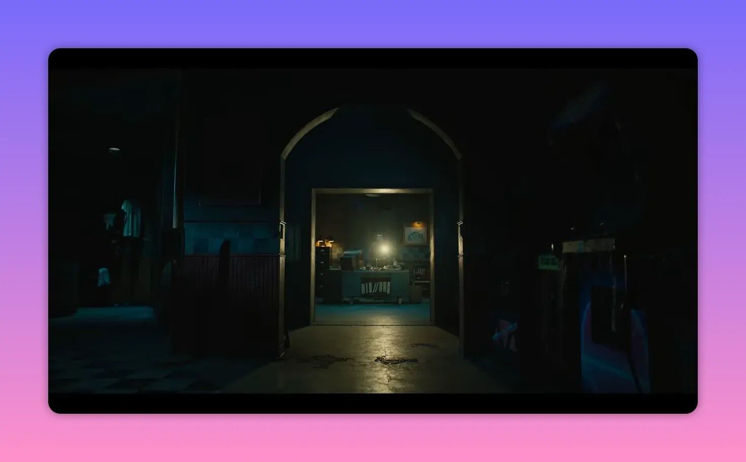 dim corridor framed by an archway leading to a lit security office desk